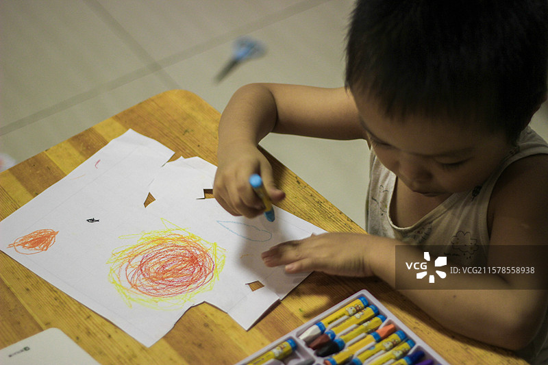 五岁小男孩使用蜡笔涂画太阳系行星恒星 剪纸摆设图片素材