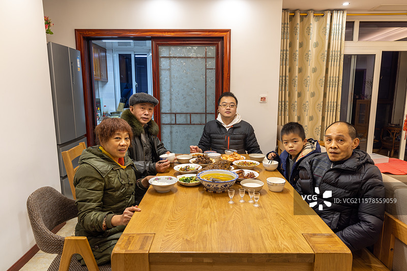 八岁小男孩和家人一起吃年夜饭图片素材