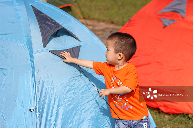 四岁小男孩在南充升钟湖风景区湖边摆弄露营帐篷图片素材