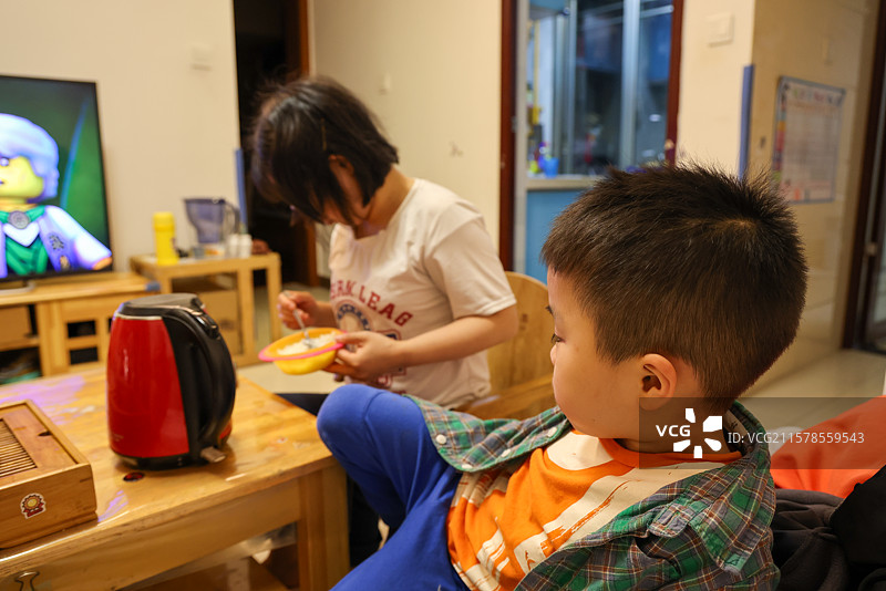 母亲给六岁的小男孩喂饭图片素材