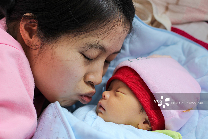 母亲亲吻刚出生二十九天的小婴儿图片素材