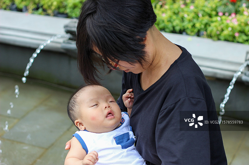 母亲抱着六个多月大的婴儿游玩都江堰景区图片素材