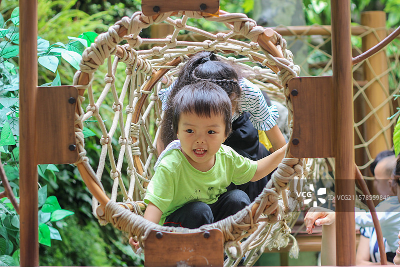 三岁小男孩在四川科技馆内绳网攀爬图片素材