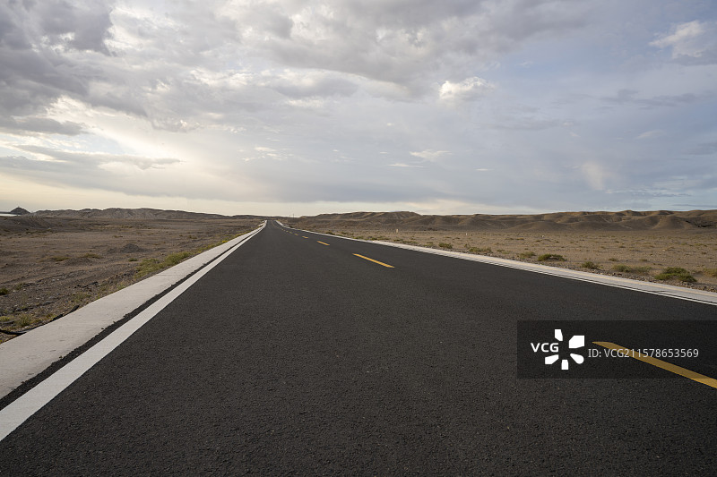 蓝天白云映衬瓜州戈壁滩黑色公路图片素材