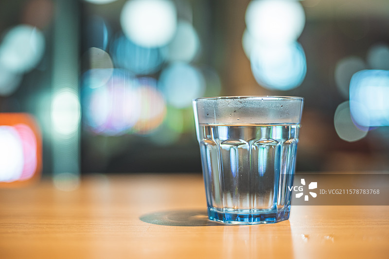 中国城市健康生活拍摄主题，住宅内部环境，茶几上的玻璃杯和柠檬水，背景是城市夜景，室内无人图像摄影图片素材