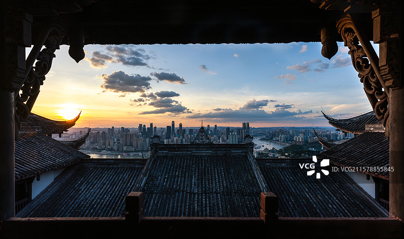 在南山老君洞寺院的顶楼看重庆的日落，城市建筑刚好在寺院屋顶之上图片素材