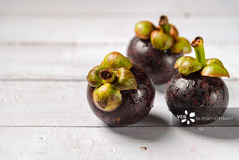 新鲜的山竹放在白色木桌上图片素材