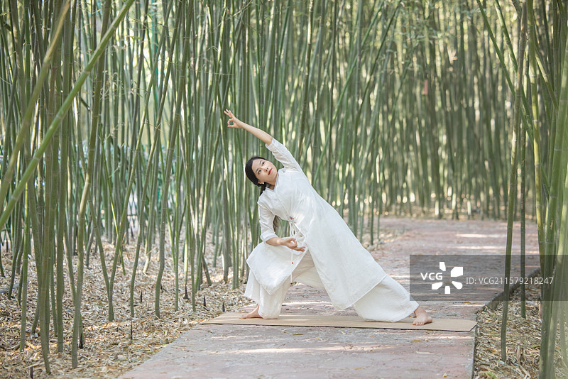 年轻女人在竹林中做瑜伽图片素材