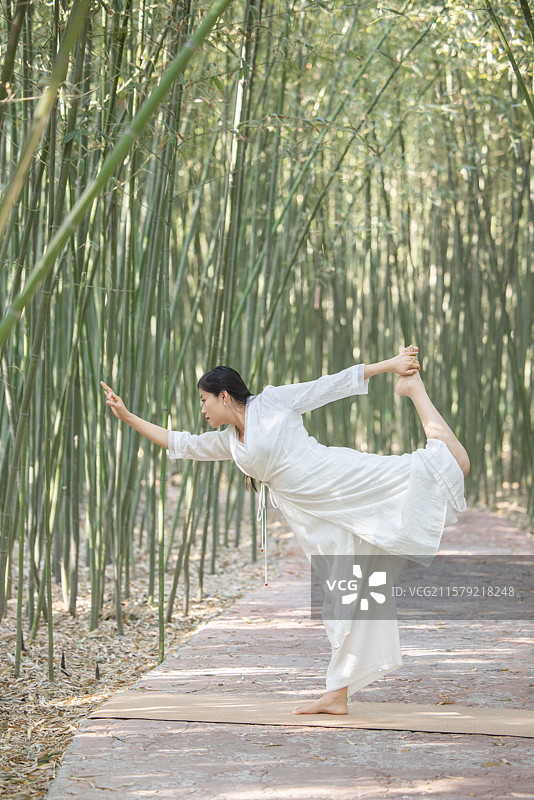 年轻女人在竹林中做瑜伽图片素材