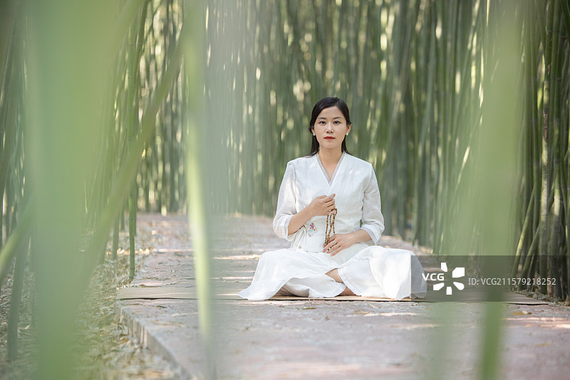 年轻女人在竹林中做瑜伽图片素材
