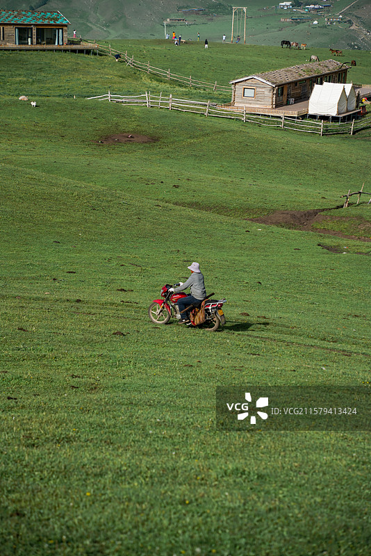 在新疆草原中骑摩托车的牧民图片素材