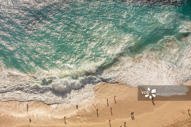 精灵坠崖下方海滩的俯拍浪涌画面与人物互动构图图片素材