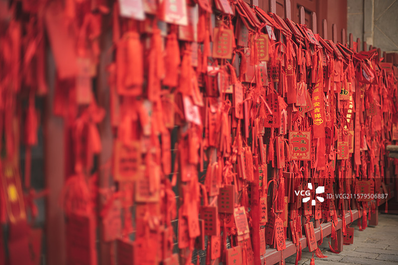 中国道教宗教象征传统文化拍摄主题  ,铁栏杆子上悬挂着大量红色许愿牌子，户外白昼无人图像摄影图片素材