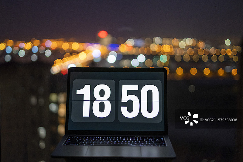 夜间霓虹灯下的苹果笔记本电脑图片素材