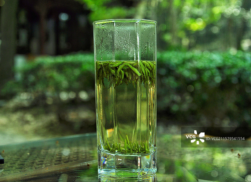 桌子上盛有绿茶君山银针的玻璃杯特写镜头图片素材