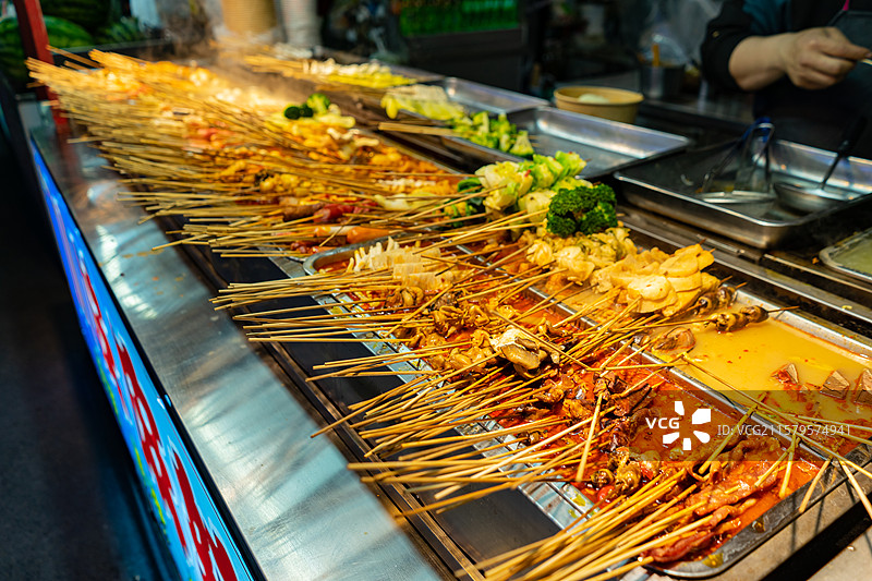 中国餐饮行业饮食产业，传统经典中国食品，夜市锅里的麻辣串炸串美食特写，户外夜晚无人图像图片素材
