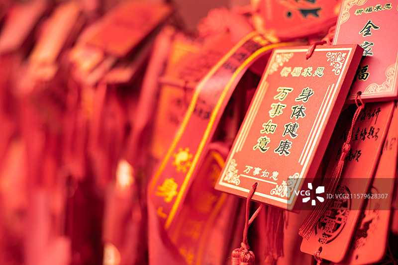 中国道教宗教象征传统文化拍摄主题  ,铁栏杆子上悬挂着大量万事如意身体健康许愿牌子，户外白昼无人图像图片素材