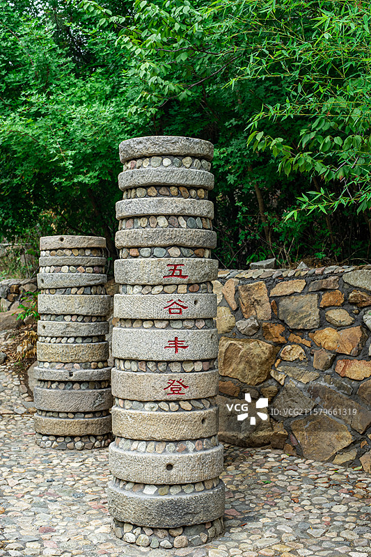 中国山东省泰安泰山汉东御道风景区，堆砌的五谷丰登传统农业工具石磨 石槽碾，户外白昼无人图像摄影图片素材