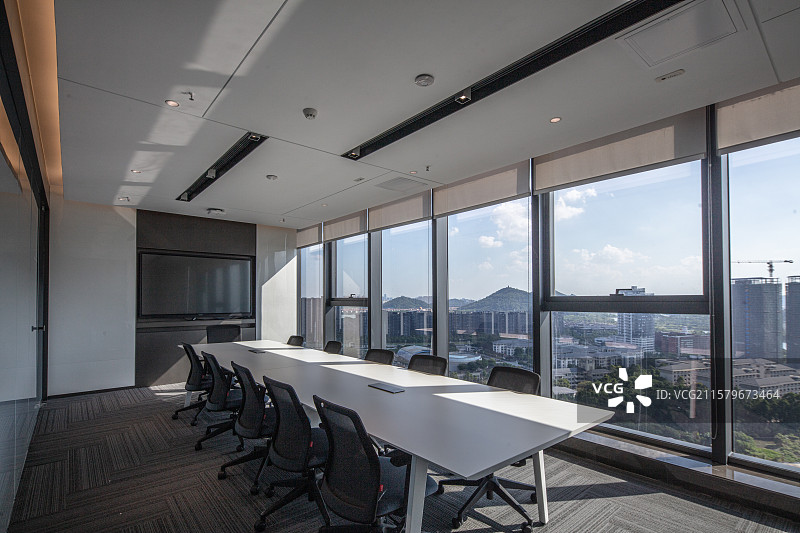 落地窗会议空间中的白色长桌与黑椅组合图片素材