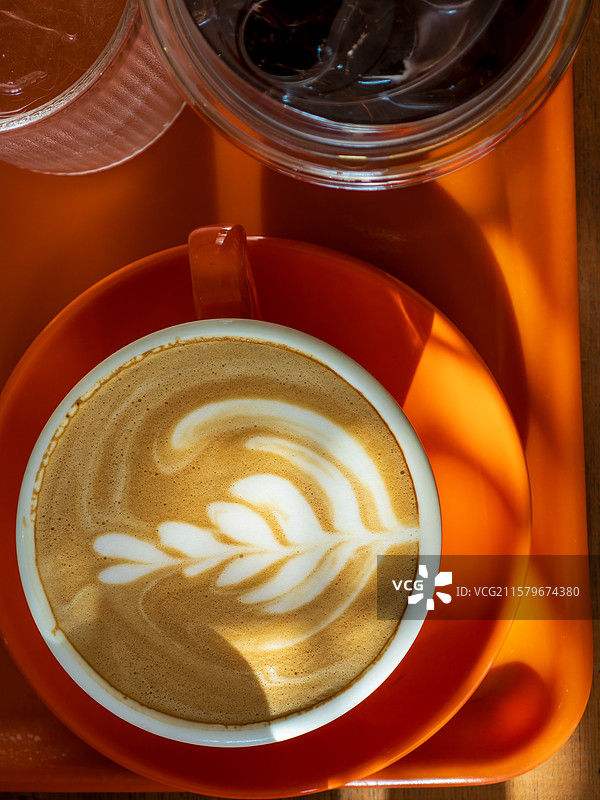 木制桌上摆放着拉花咖啡和冰美式图片素材
