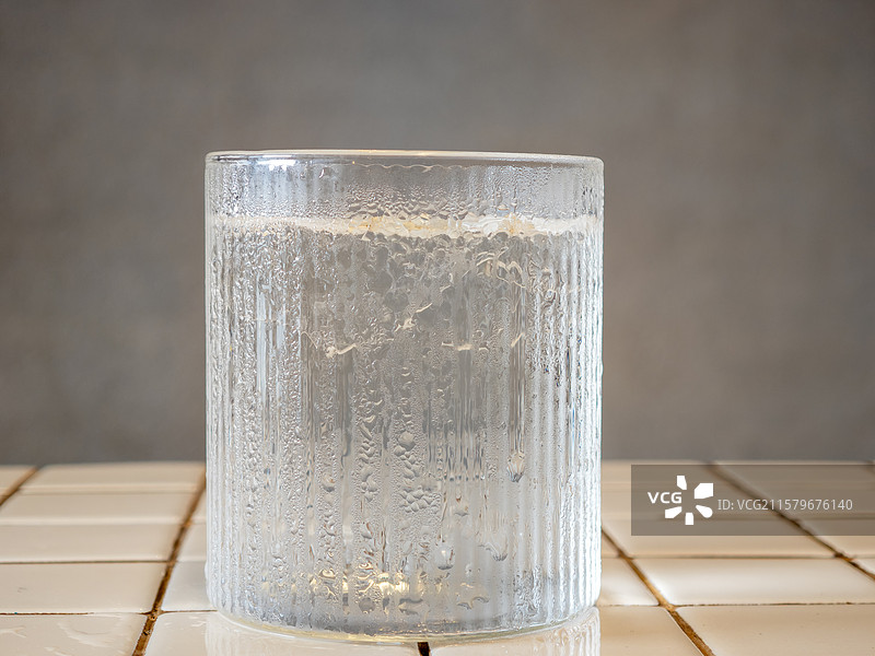 竖条纹玻璃杯中装着清澈的冰镇饮用水图片素材