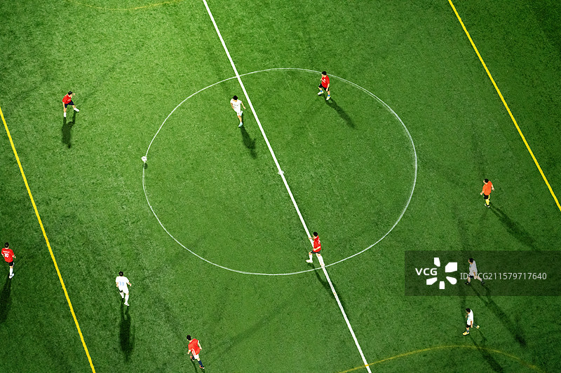 夜晚足球场上踢足球的人们图片素材