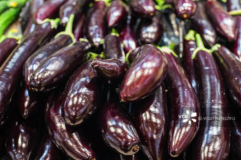 中国水果果蔬拍摄主题，超级市场零售货摊上一堆的紫色的长茄子蔬菜产品，室内无人图像摄影图片素材