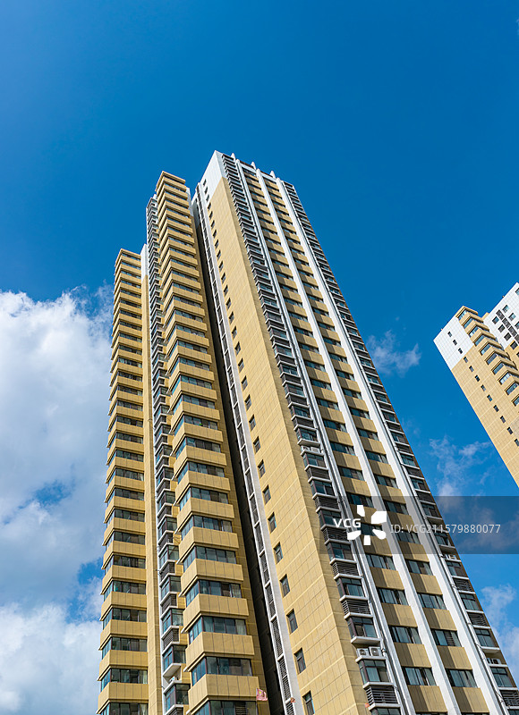 中国房地产拍摄主题，低视角仰拍居住区高层楼房和天空中的蓝天和云景，户外白昼无人图像摄影图片素材