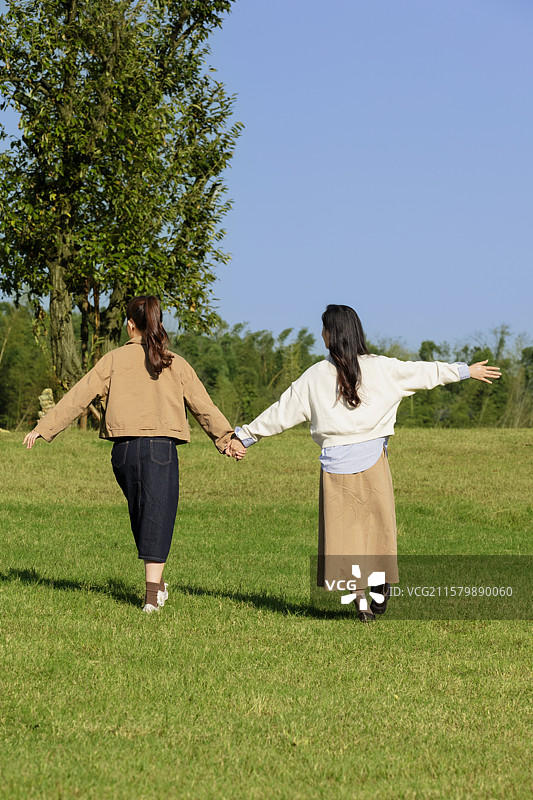 在户外露营基地享受自由感觉的两个年轻女子图片素材