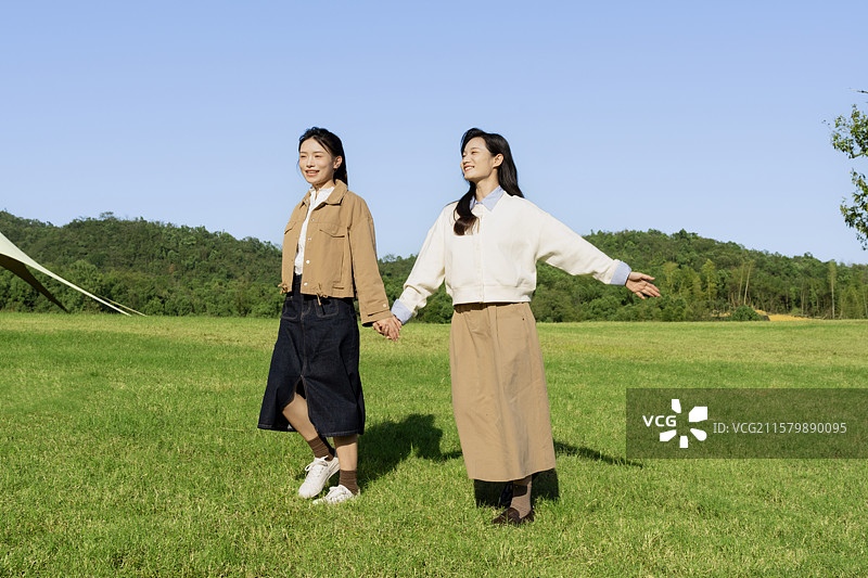 在户外露营基地享受自由感觉的两个年轻女子图片素材