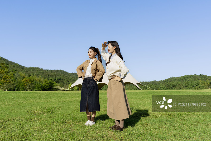 在户外露营基地享受自由感觉的两个年轻女子图片素材