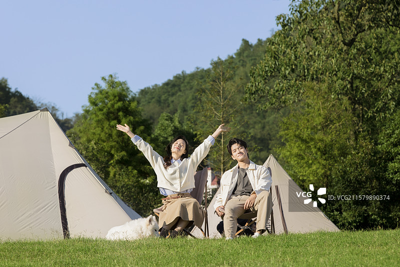 坐在帐篷前休闲聊天的年轻情侣图片素材