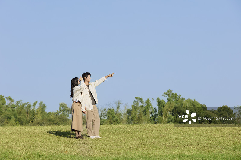 秋日里在户外散步的年轻情侣图片素材