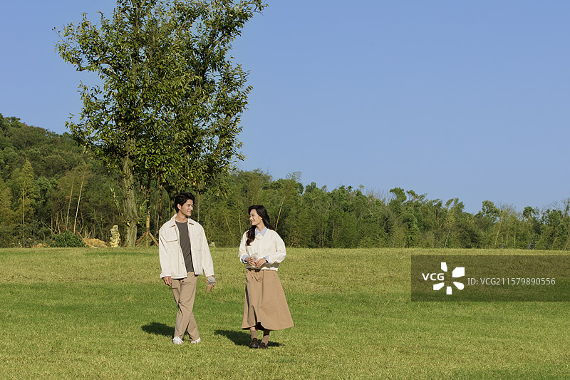 秋日里在户外散步的年轻情侣图片素材