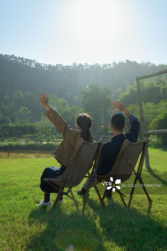 坐在帐篷前休息聊天的年轻情侣图片素材