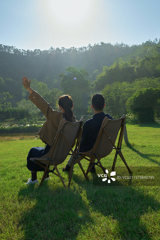坐在帐篷前休息聊天的年轻情侣图片素材
