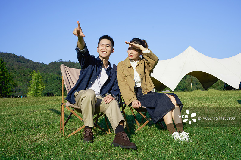 坐在帐篷前休息聊天的年轻情侣图片素材