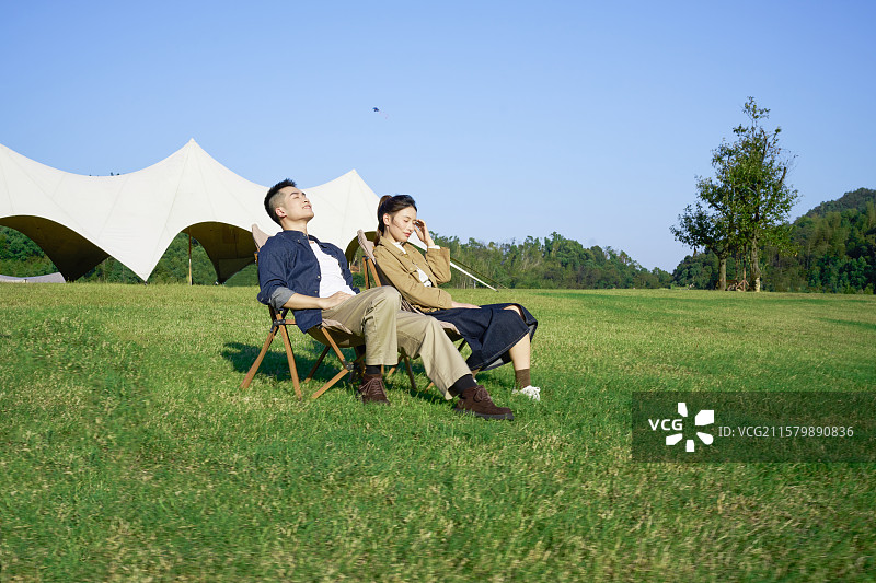 坐在帐篷前休息聊天的年轻情侣图片素材