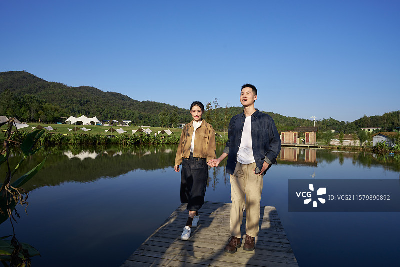站在湖边观看远方的年轻情侣图片素材