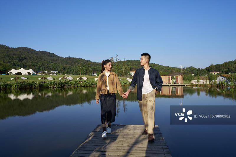 站在湖边观看远方的年轻情侣图片素材