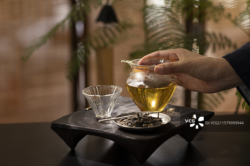 泡茶： 手拿着玻璃公道杯图片素材