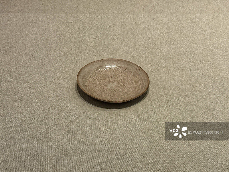 中国丝绸博物馆碧色万里特展展出内蒙古阿鲁科尔沁旗博物馆藏辽代白釉刻莲花石榴纹盘图片素材
