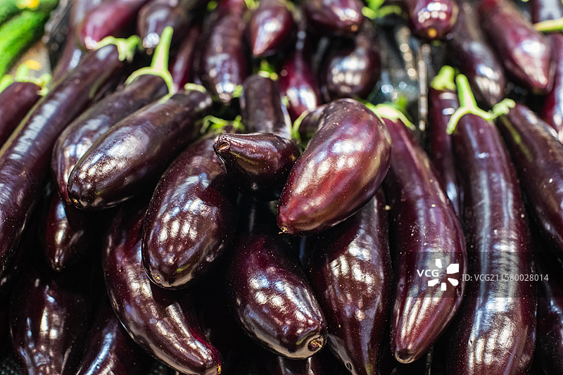 中国水果果蔬拍摄主题，超级市场零售货摊上一堆的紫色的长茄子蔬菜产品，室内无人图像摄影图片素材