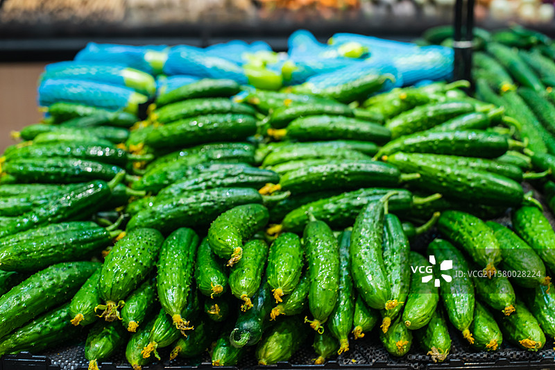 中国水果果蔬拍摄主题，超级市场零售货摊上一堆的绿色的黄瓜蔬菜产品，室内无人图像摄影图片素材