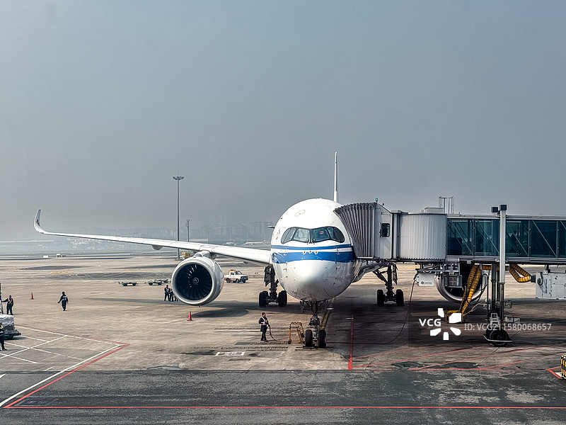6月22日，首都机场，打开廊桥等待上客的民航飞机图片素材