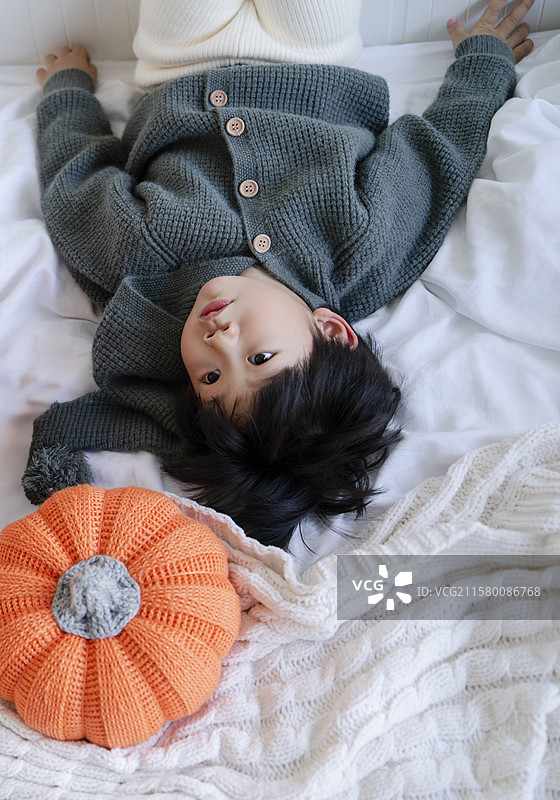 可爱小男孩与彩色毛线大南瓜高角度视图图片素材