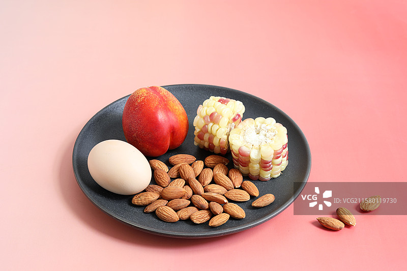桌面上的一盘子营养早餐坚果鸡蛋水果玉米图片素材