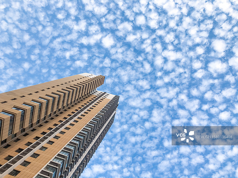 中国房地产拍摄主题，低视角仰拍居住区高层楼房和天空中的蓝天和鱼鳞云，户外白昼无人图像摄影图片素材
