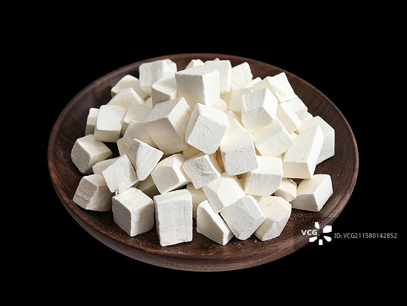 黑色背景上的一盘中国中医中药材白茯苓的特写图片素材