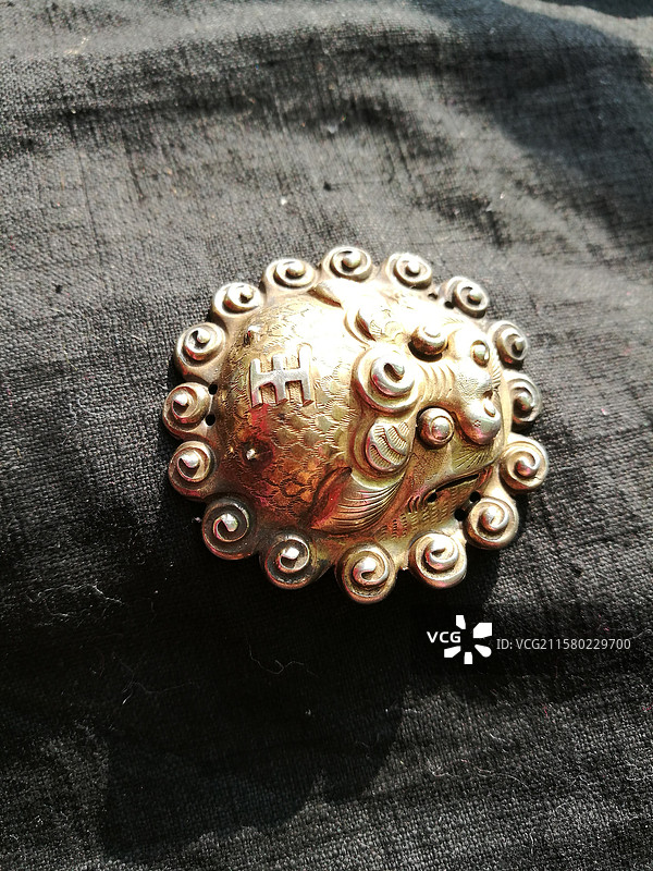 黑色纯色背景下的老银鎏金狮虎头帽正。老饰品老首饰图片素材